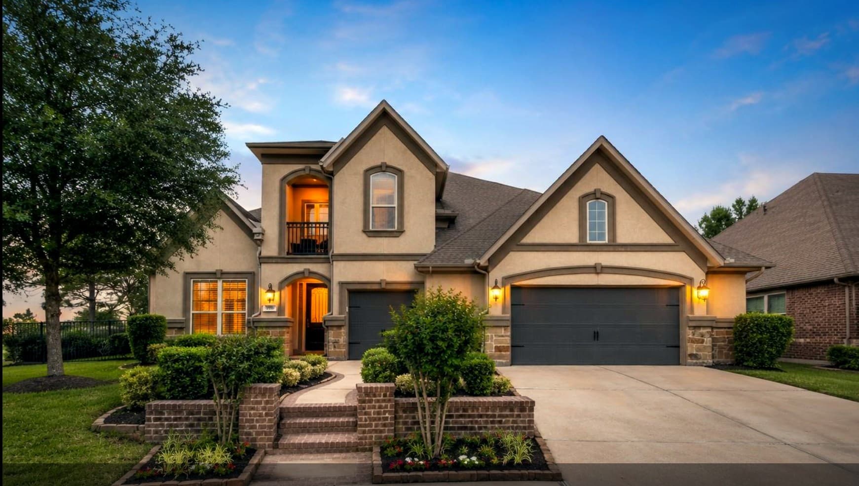Bear Builders two-story brick custom home at dusk